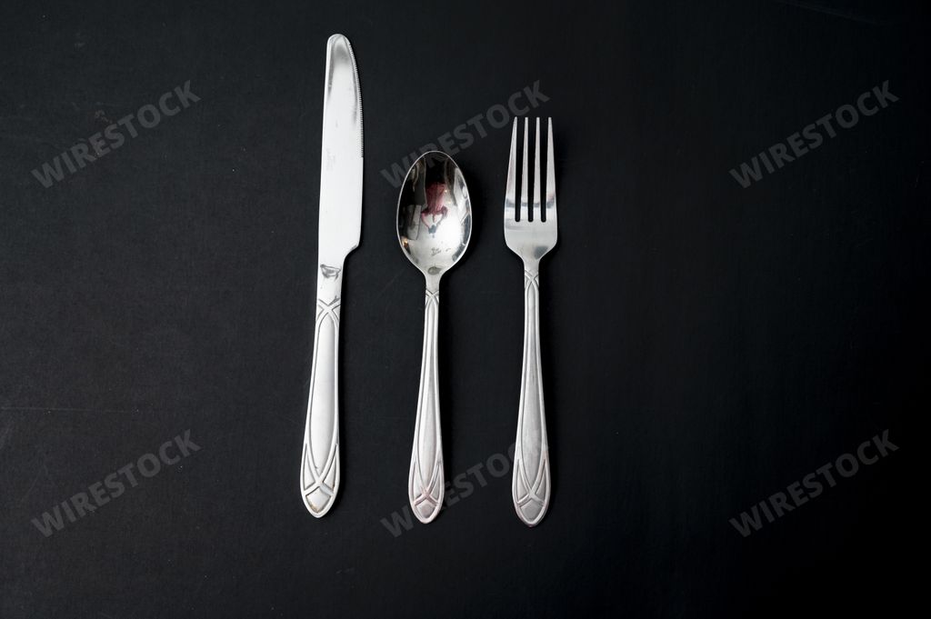 A horizontal shot of knife, spoon, and fork