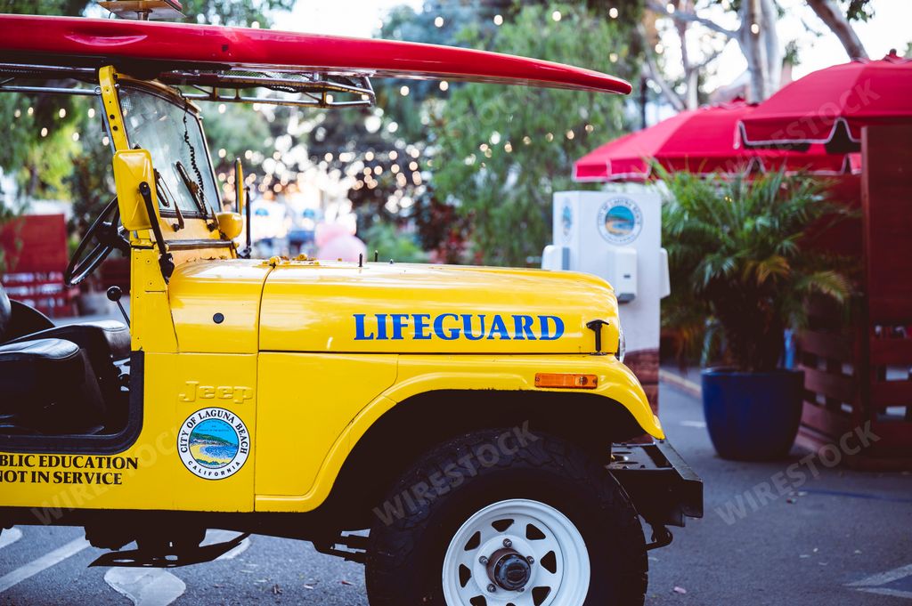 A Yellow Lifeguard Jeep, rescue vehicle with surfboard at Laguna Beach in United States