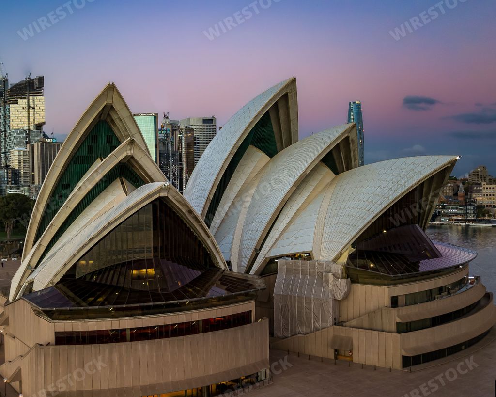 A closeup of iconic world building - Sydney Opera house in full glory at sunset against a colorful sky