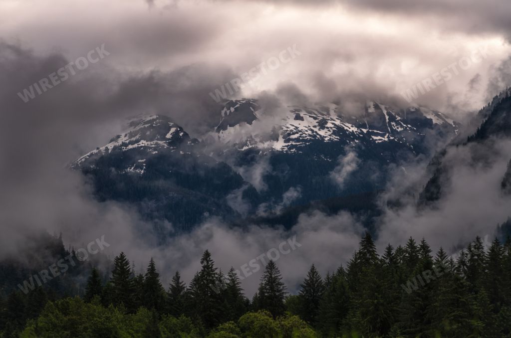 A mesmerizing shot of the snowy landscapes covered with dark clouds in winter