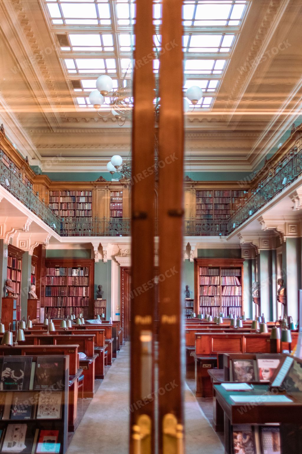 A vertical shot of a library from behind a glass door