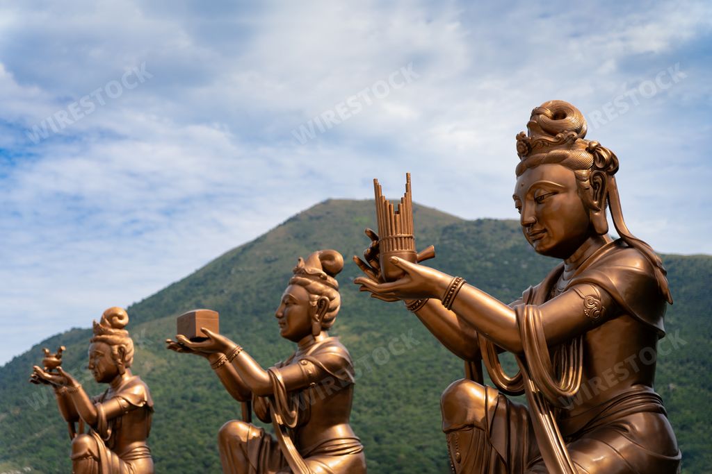 Statue of Hindu deities seated on a pedestal with a standing figure
