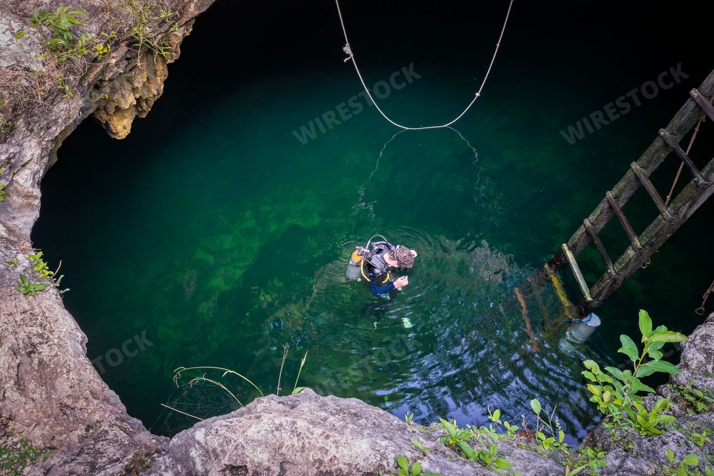 A male diver in the Cenote Calavera water, Tulum, Mexico