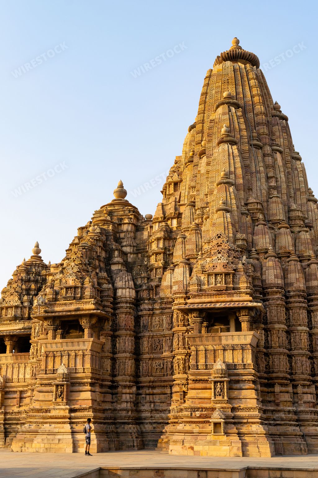 A vertical shot of Kandariya Mahadev Temple against blue sky background in India