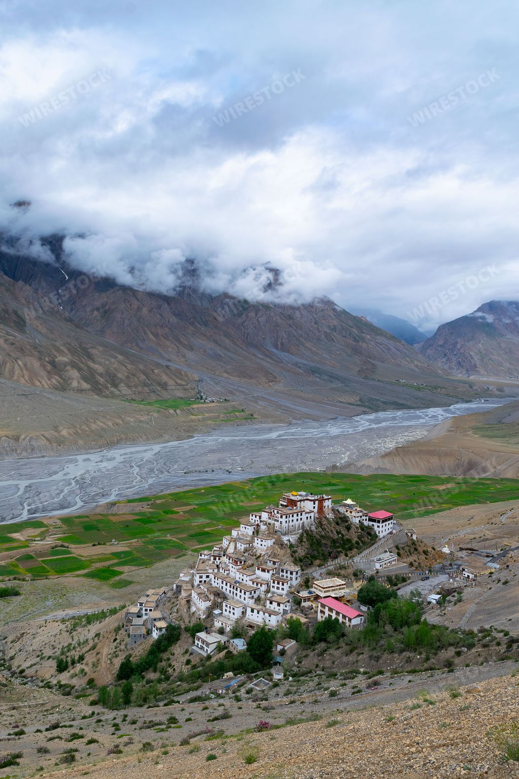 A vertical shot of Kee monastery on top of a hill in Spiti valley, India around a river and mountains