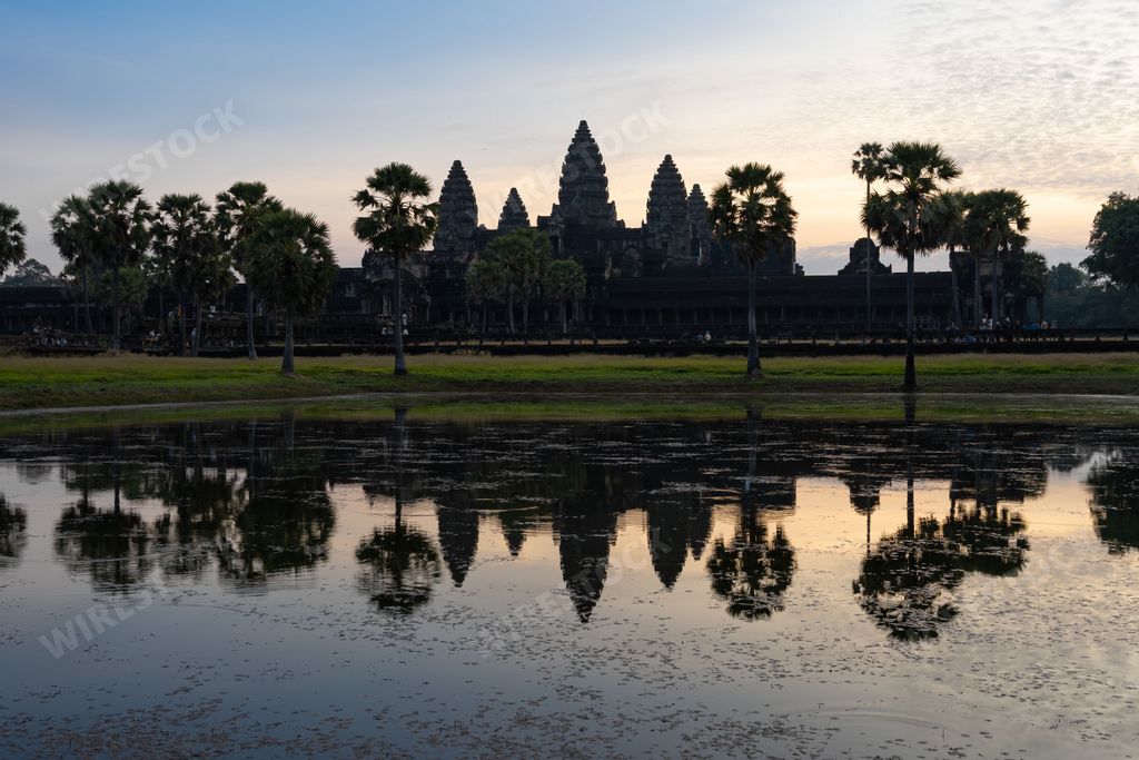 A stunning view of a lake at sunrise reflecting off the ancient Angkor Wat temple in Cambodia