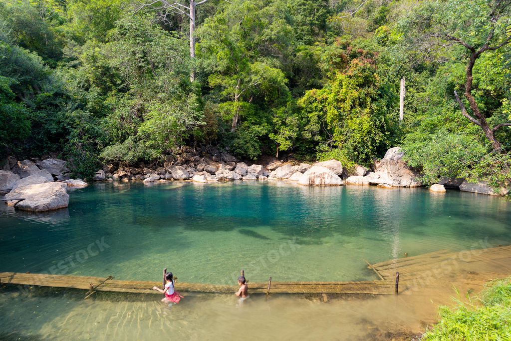 A high angle shot of kids swimming in Cool springs in Thakhek loop, Laos