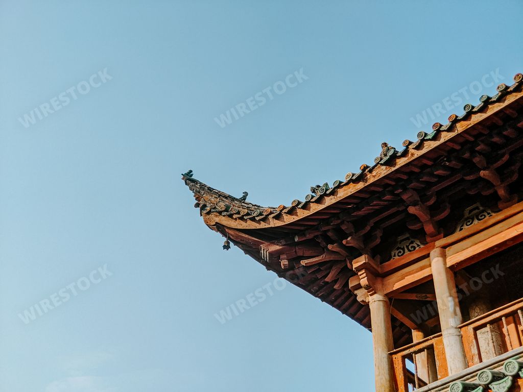 A low angle shot of a beautiful Asian temple roof on a blue sky background