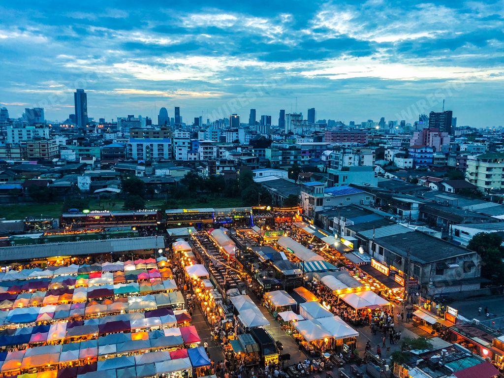 An aerial shot of market tents near buildings under a blue sky