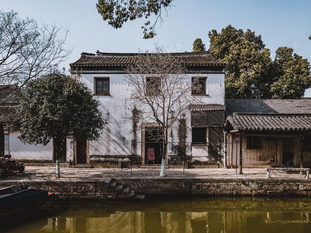 An ancient residential building with weathered old exterior walls and damaged windows in the countryside