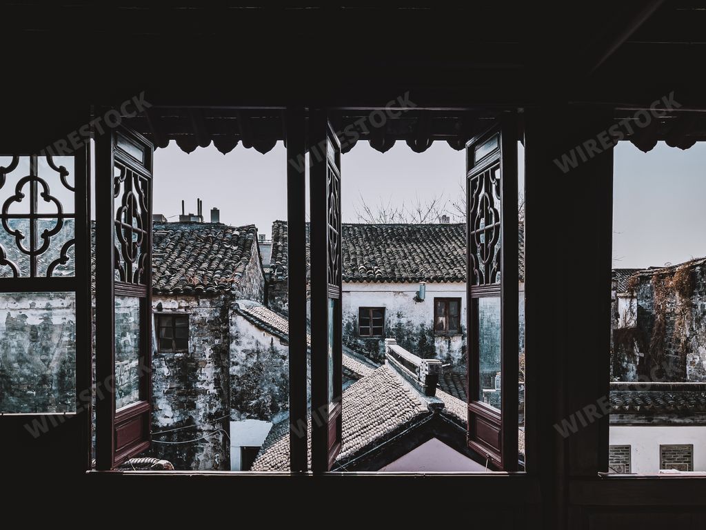 Old-styled vintage open windows with a view of old town ancient weathered residential buildings