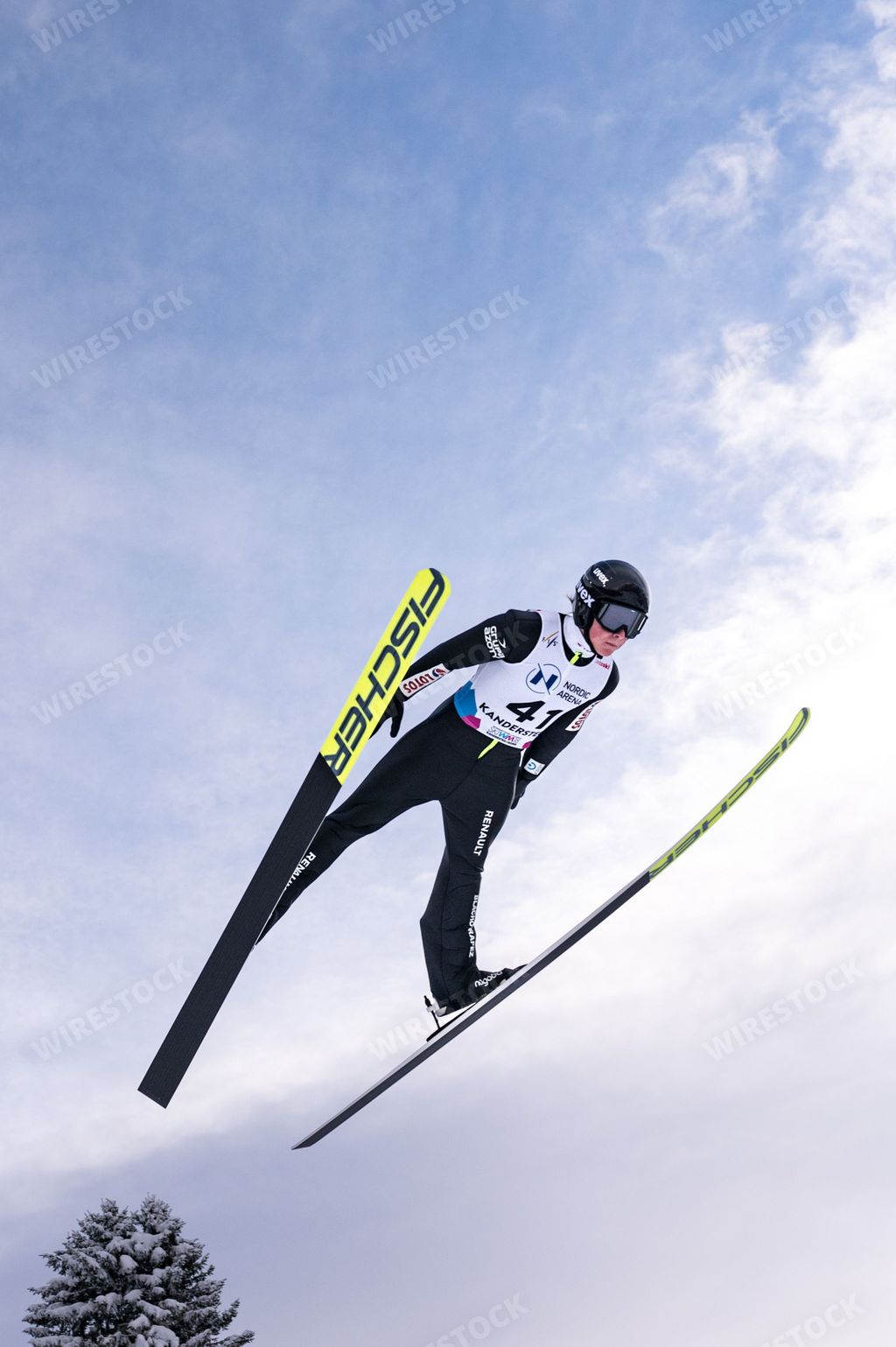 A vertical shot of a competitor during the Ski jumping Contest in Kandersteg at Nordic Arena during Wintertime, Switzerland