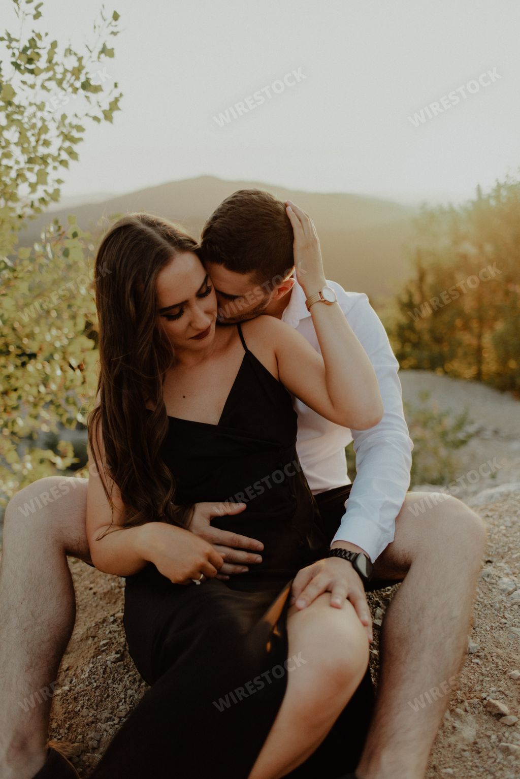 A vertical shot of a romantic couple posing on a meadow