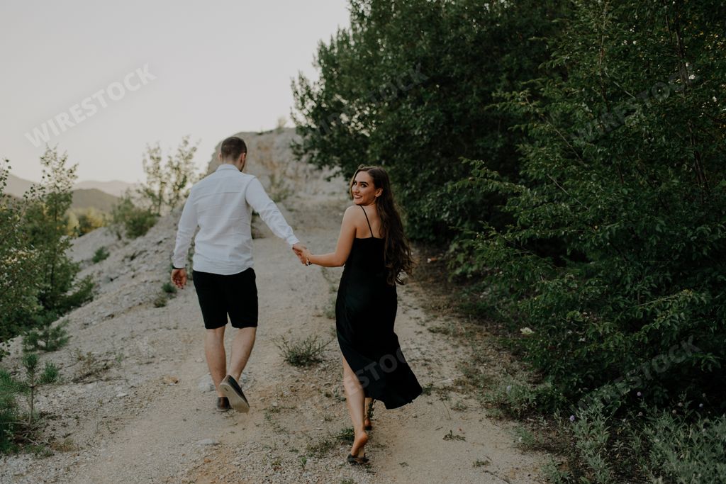 A young romantic couple walking and having fun on a park trail