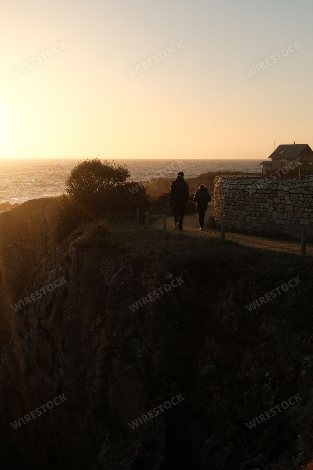 A group of individuals standing on cliff overlooking ocean