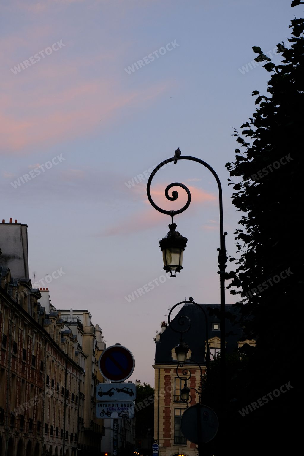 A beautiful Sunset in the sky of the Place des Vosges in Paris, France - vertical shot