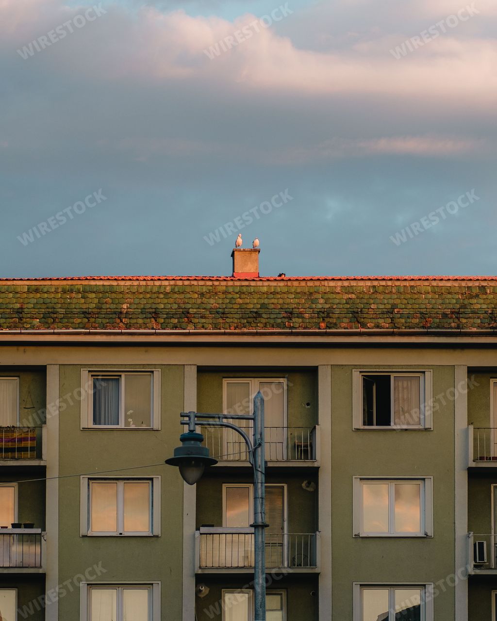 A vertical shot of a building with a light green exterior in Targu Mures, Romania, on a cloudy day