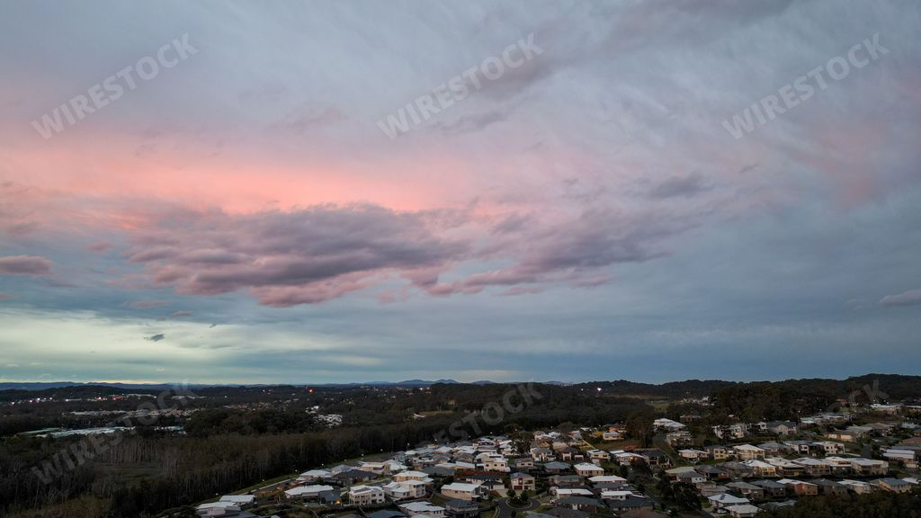 An aerial shot of the Port Macquarie town with surrounding forest at sunset in Australia
