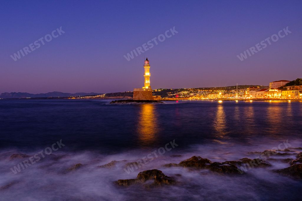 A beautiful distant view of the illuminated Chania lighthouse in Crete, Greece