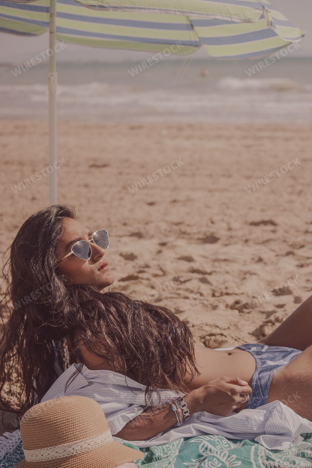 A sexy female lying on the beach and relaxing on a sunny day