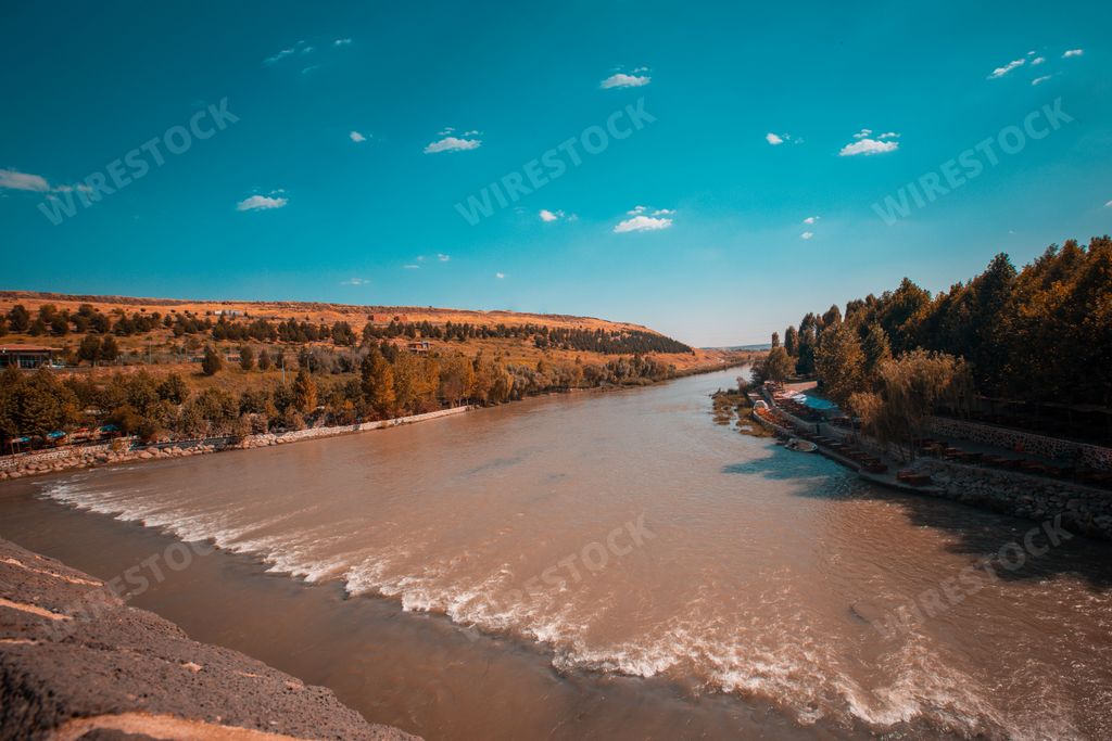 An aerial view of the Euphrates river near trees under a blue sky in Diyarbakir, Turkey