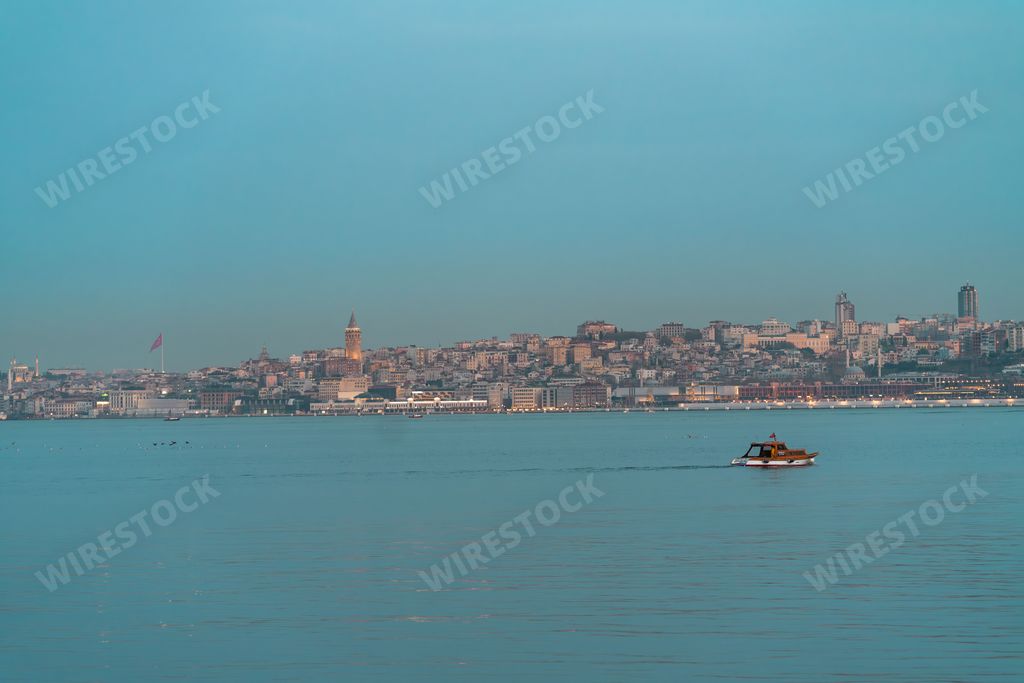 A beautiful shot of a boat sailing near a cityscape in the Bosphorus region of Turkey