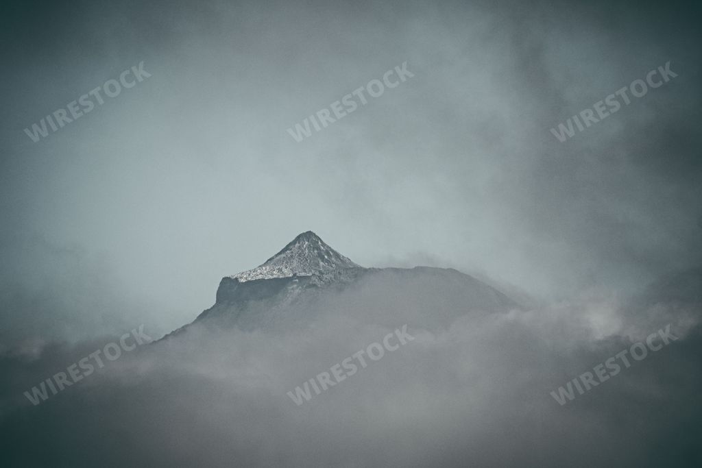 Aerial view of a mountain range surrounded by clouds