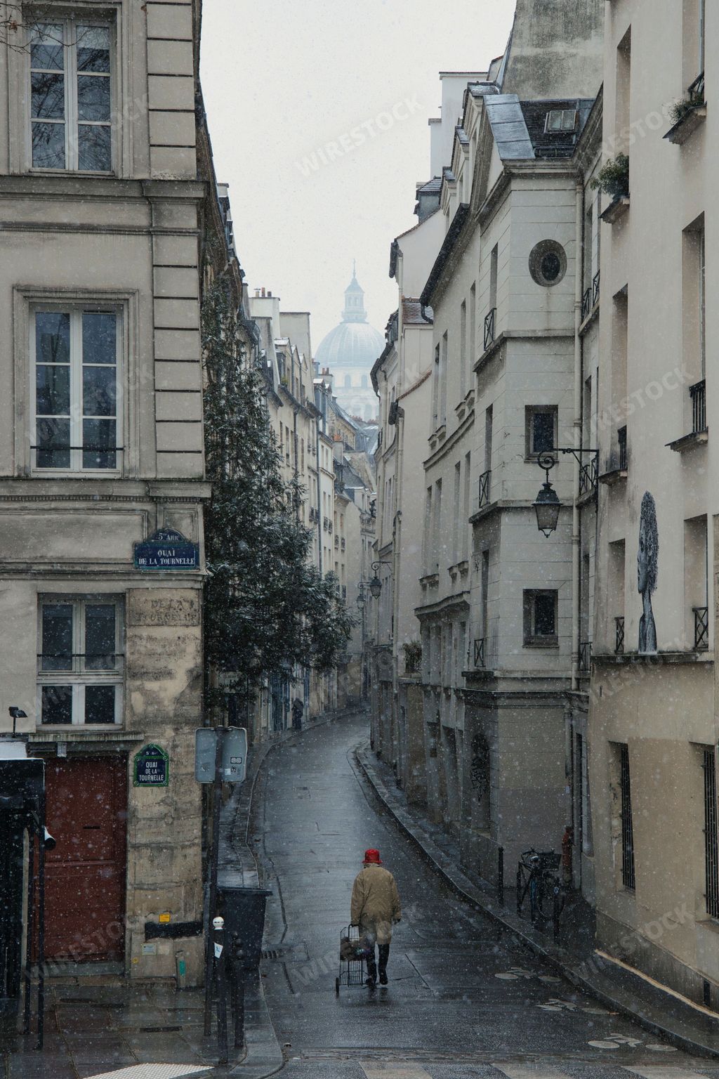 A vertical shot of a narrow street during snowfall in Paris, France