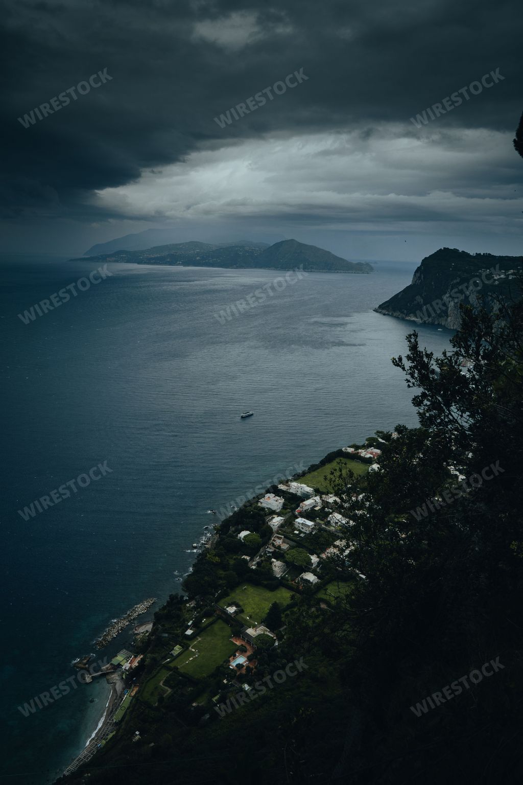A vertical high-angle of a resort near the sea with the gloomy, cloudy sky background