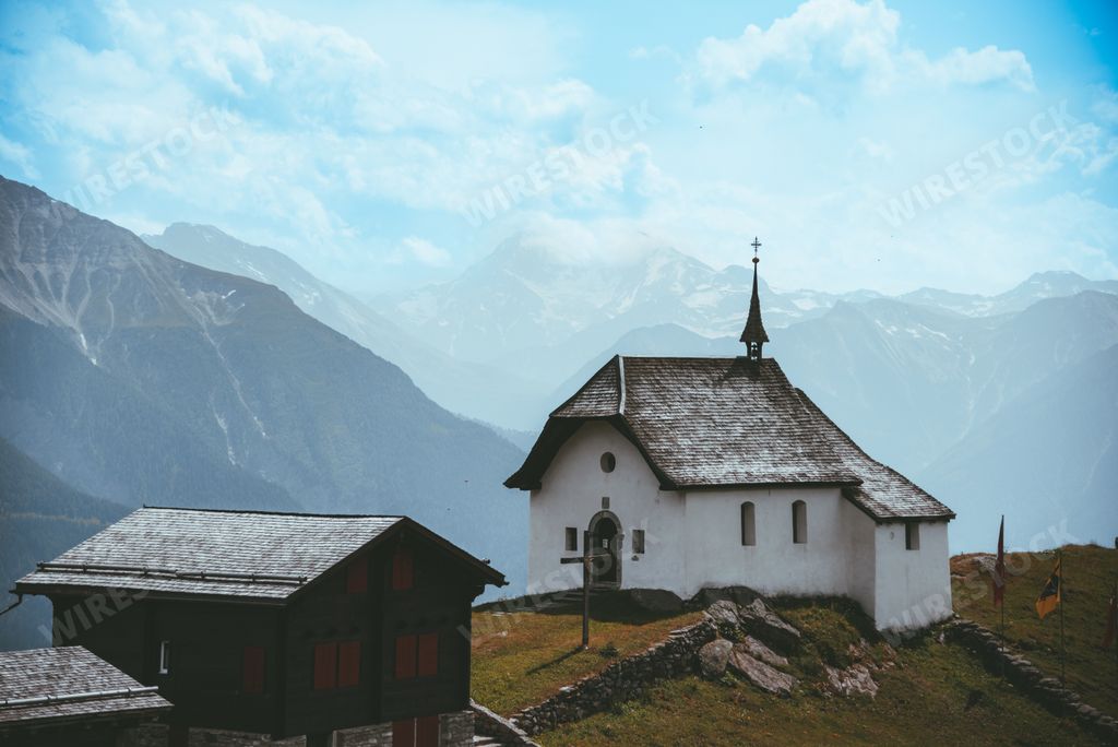 A beautiful view of the old white chapel with the mountains on the background in Bettmeralp, Switzerland