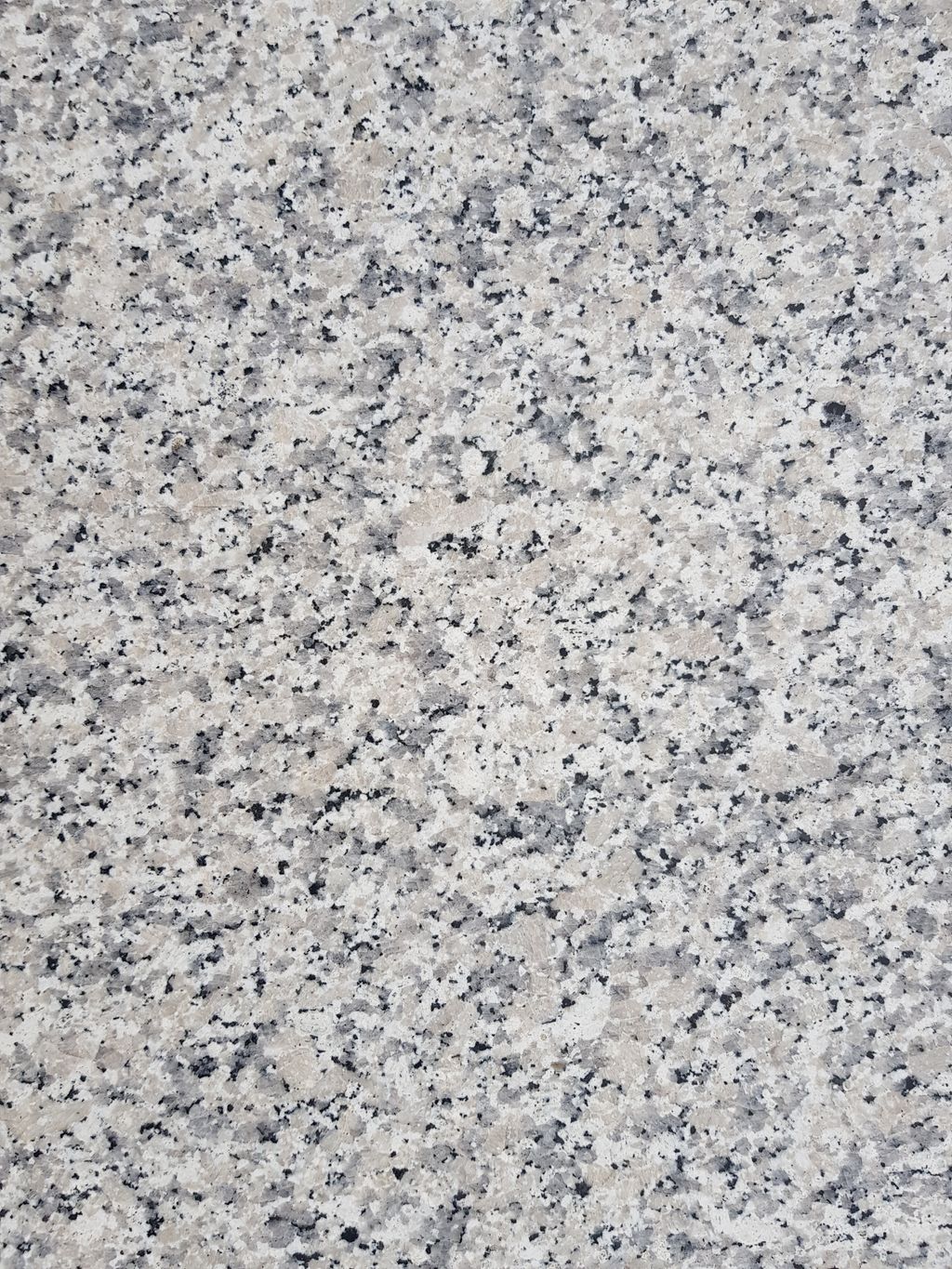 A vertical shot of a gray spotted stone texture - for background and texture