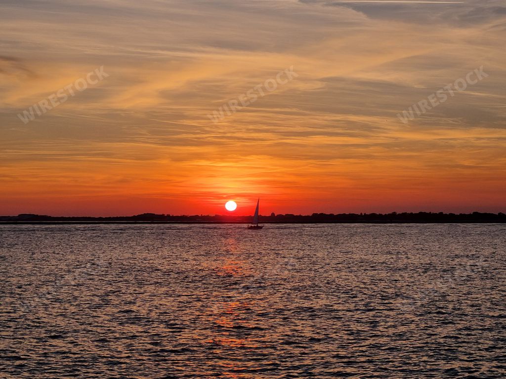 A silhouette of boat floating on water during sunset