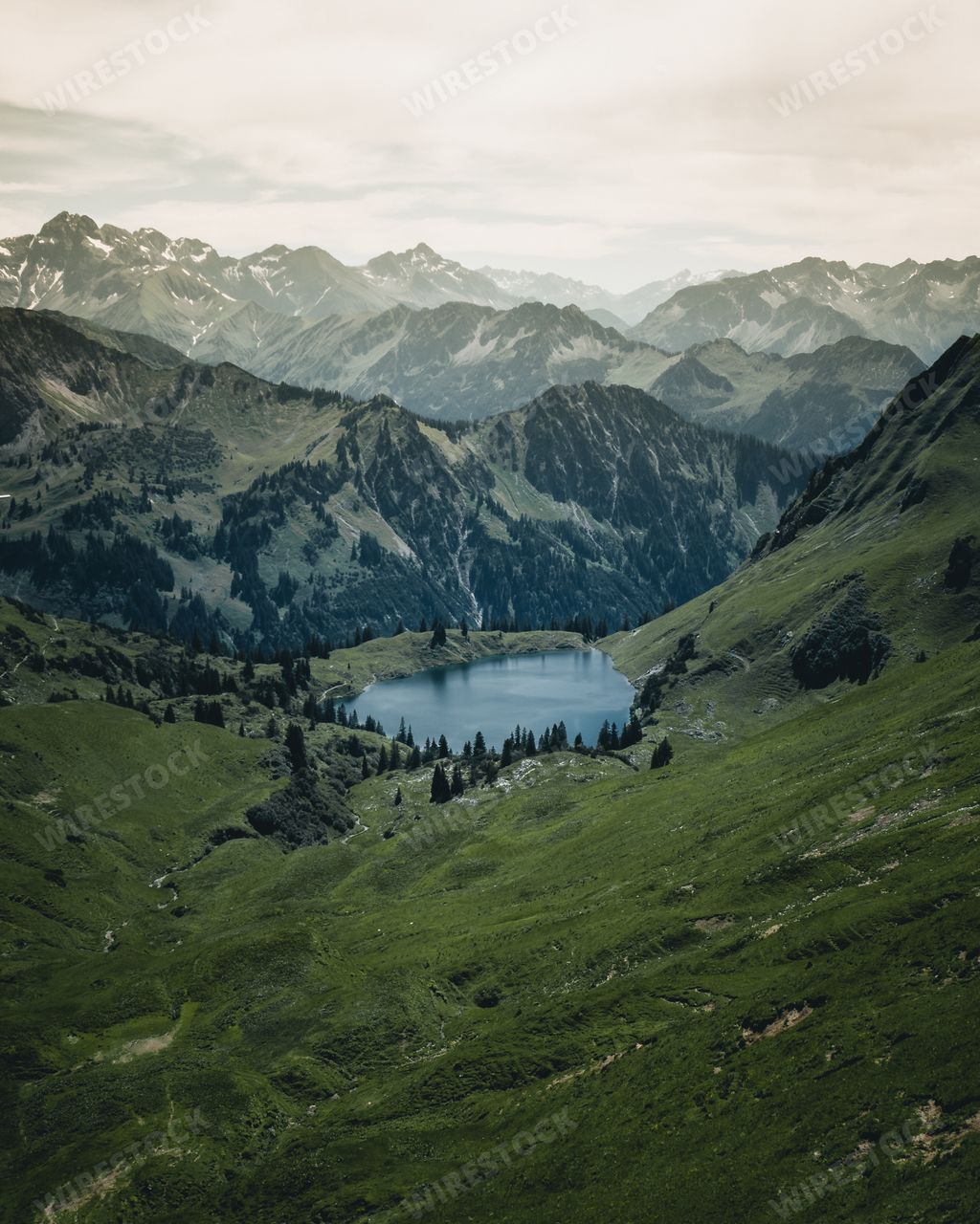 A beautiful view of a lake surrounded by rocky mountains and greenery in Switzerland