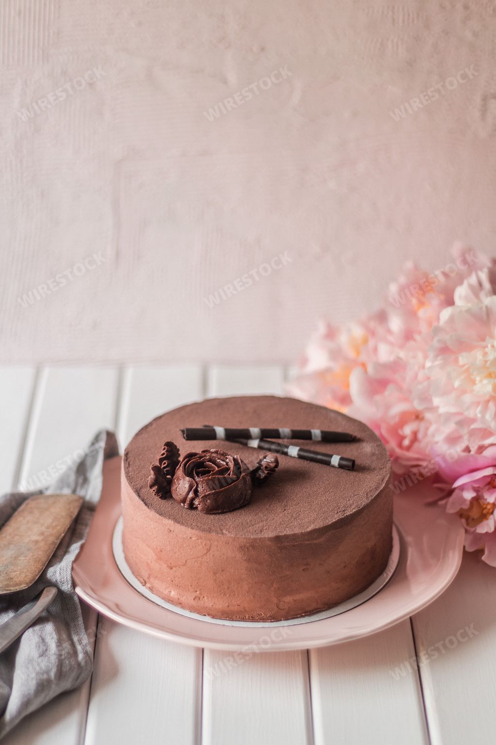 A vertical aesthetic shot of a tasty chocolate cake with a rose