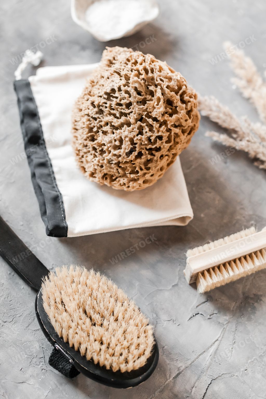 A vertical shot of plastic-free zero waste bathroom supplies for personal hygiene with an eco pouch