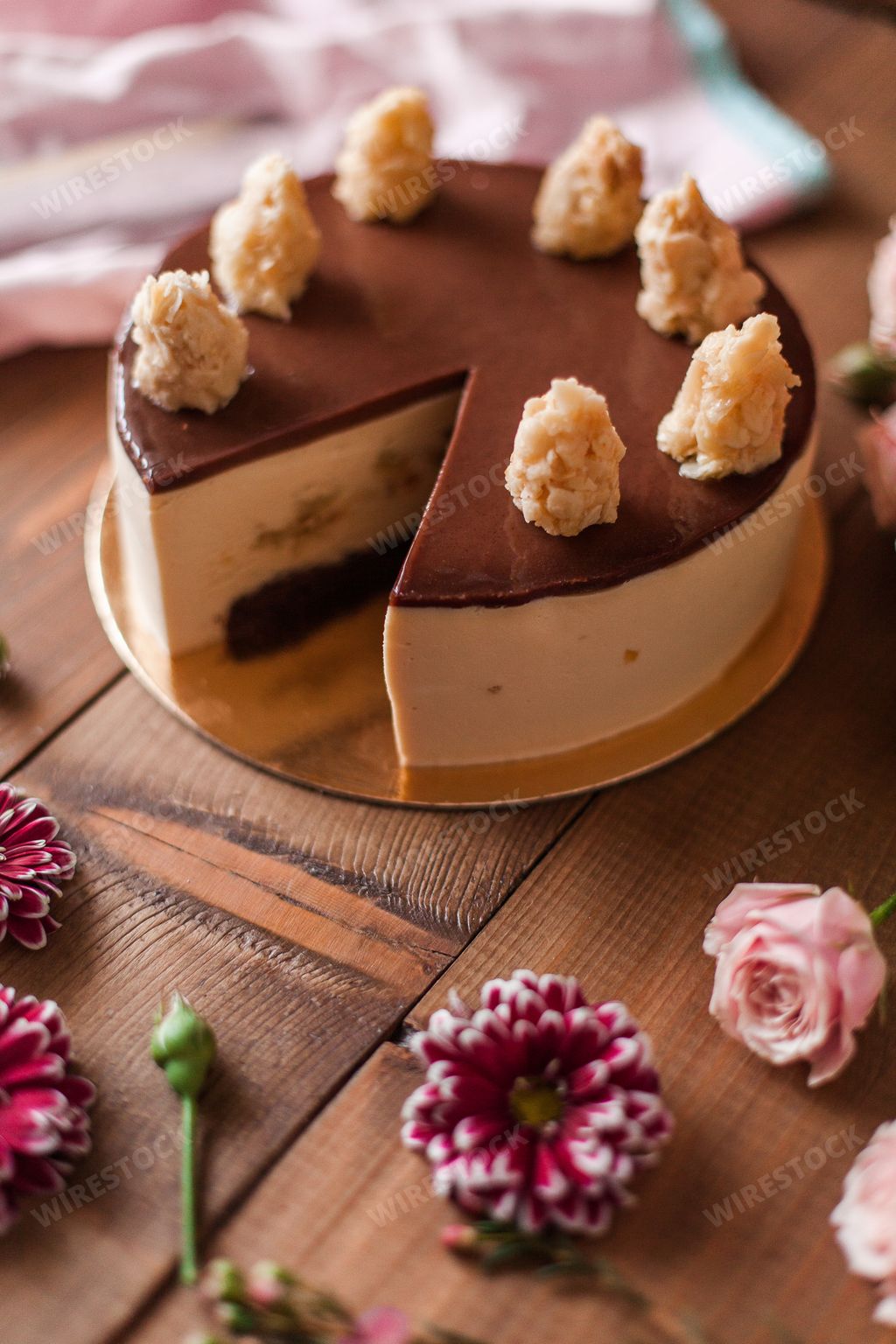 An aesthetic shot of a chocolate cheesecake arranged with delicate flowers