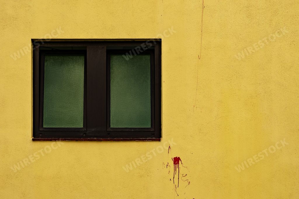 A beautiful shot of a yellow wall with a black window on the left and red spots - perfect for an article about a criminal story