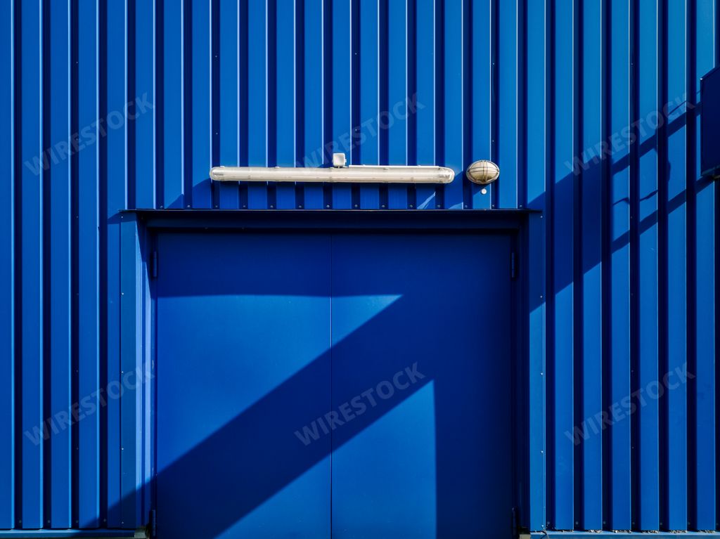 A closeup shot of an old metal building with a shadow during daytime