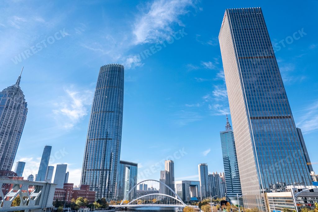 A low-angle view of city full of skyscrapers under the blue sky.