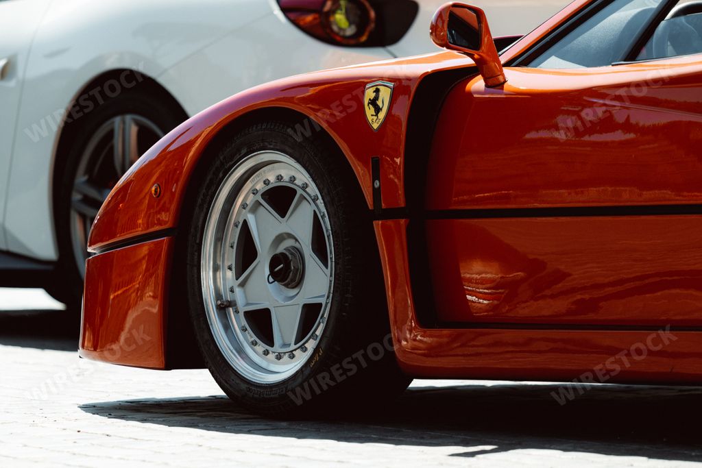 A side view shot of a red Ferrari F40 car in the street