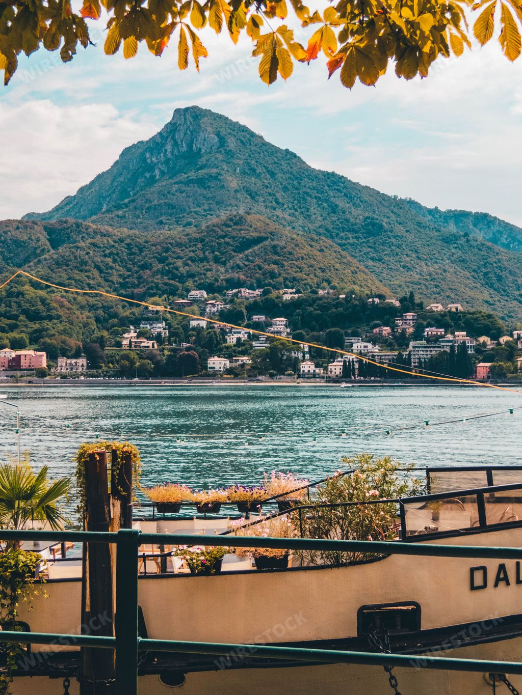 A vertical shot of the calm Como Lake in Lecco city Italy with big mountains in the background