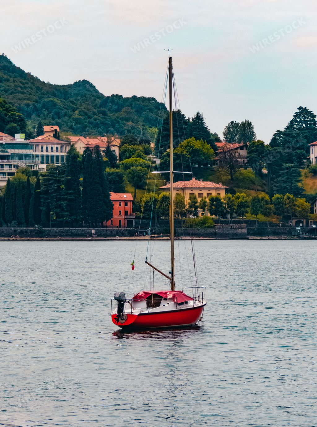 A vertical shot of a red boat sailing in italy
