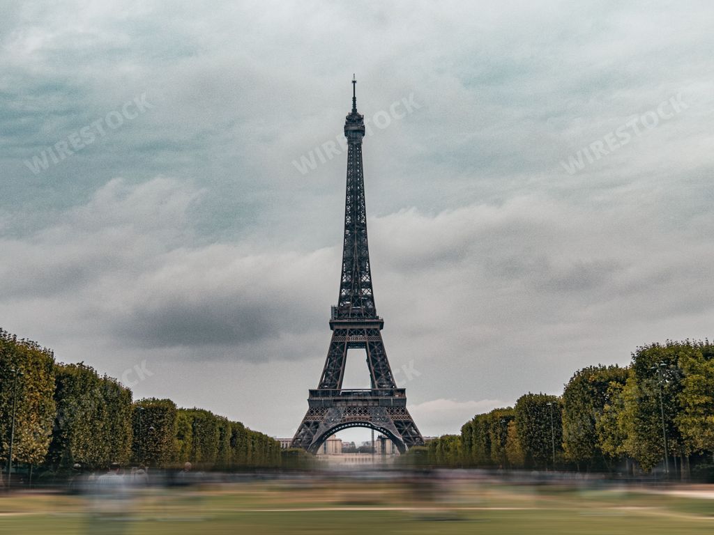 Busy Eiffel Tower in Paris, France, in a rainny summer day