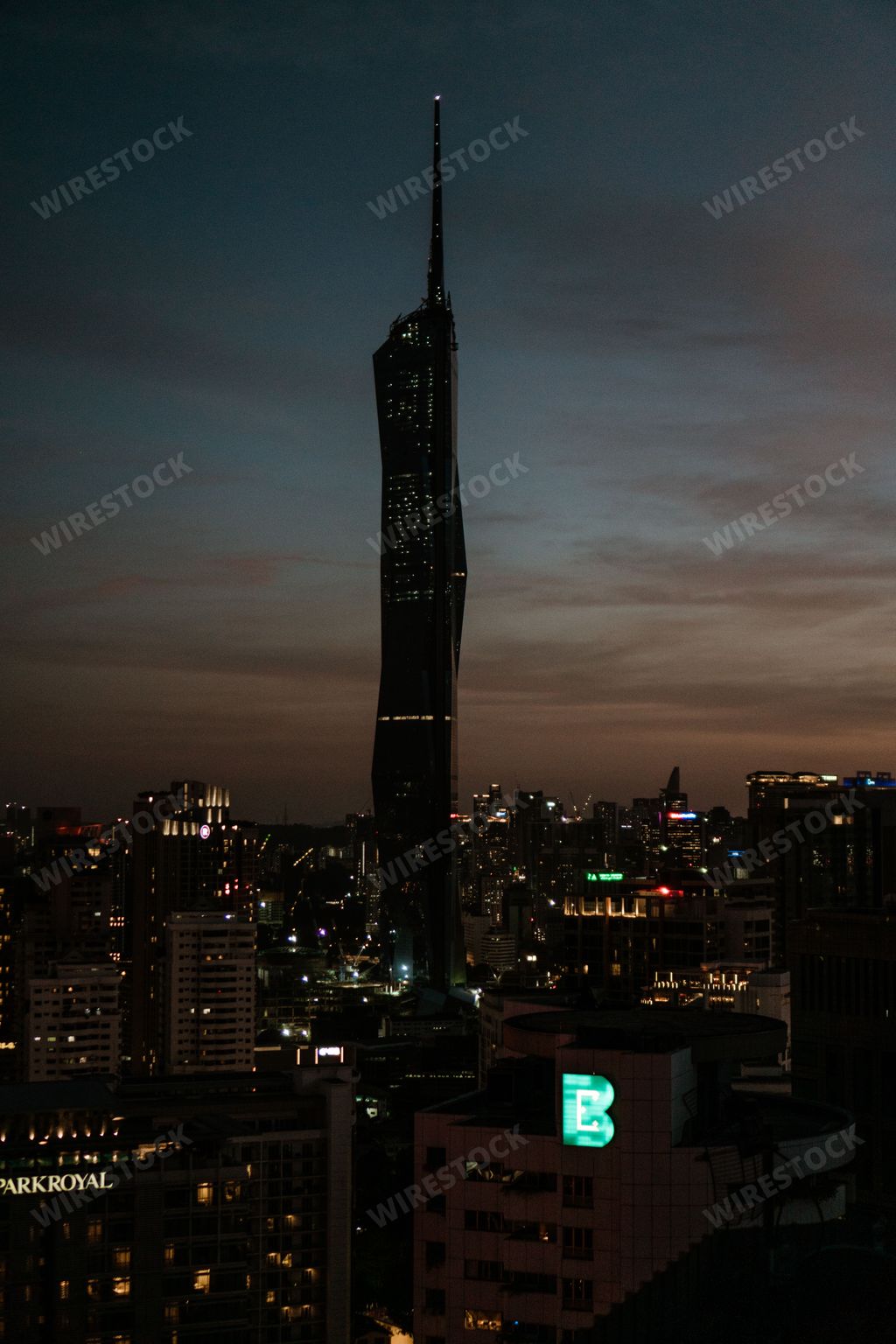 A vertical shot of the silhouette of Warisan Merdeka Tower in Kuala Lumpur during the sunset