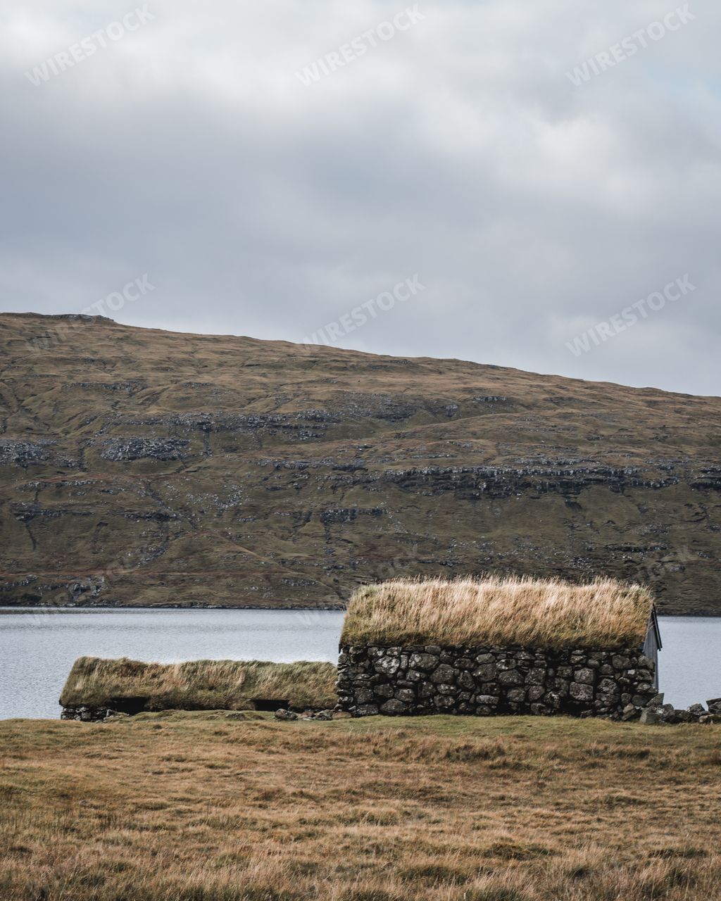 House from stones with grass rooftop, Faroe Islands. View of typical turf-top houses. Panoramic autumn scene of Faroe Islands. Moody dark landscape