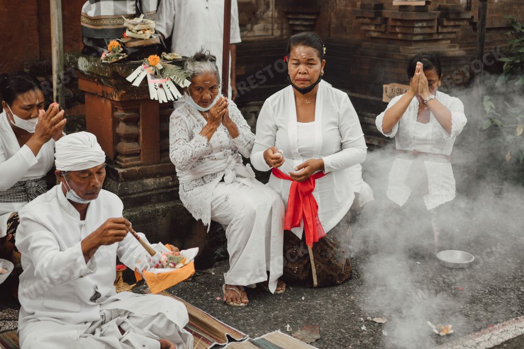 Balinese people in traditional white sarong during Hindu ceremony in Bali