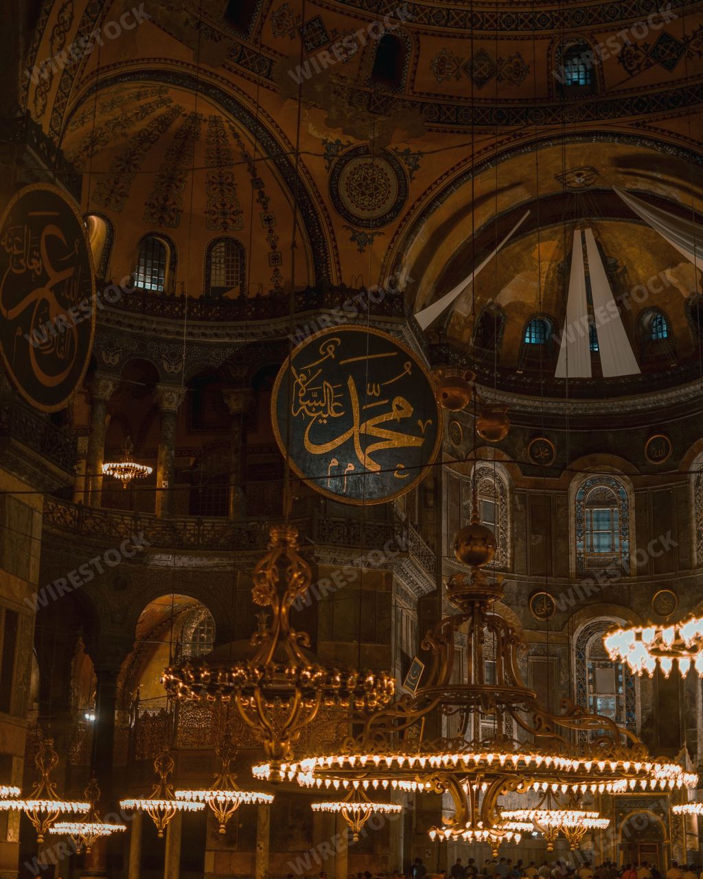 A vertical shot of the Hagia Sophia interior with a calligraphy quotation in the center