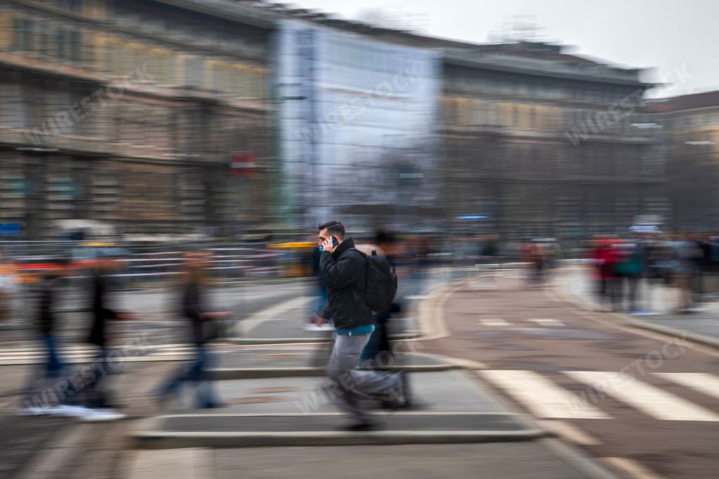A beautiful shot of a man running fast in haste while on the phone