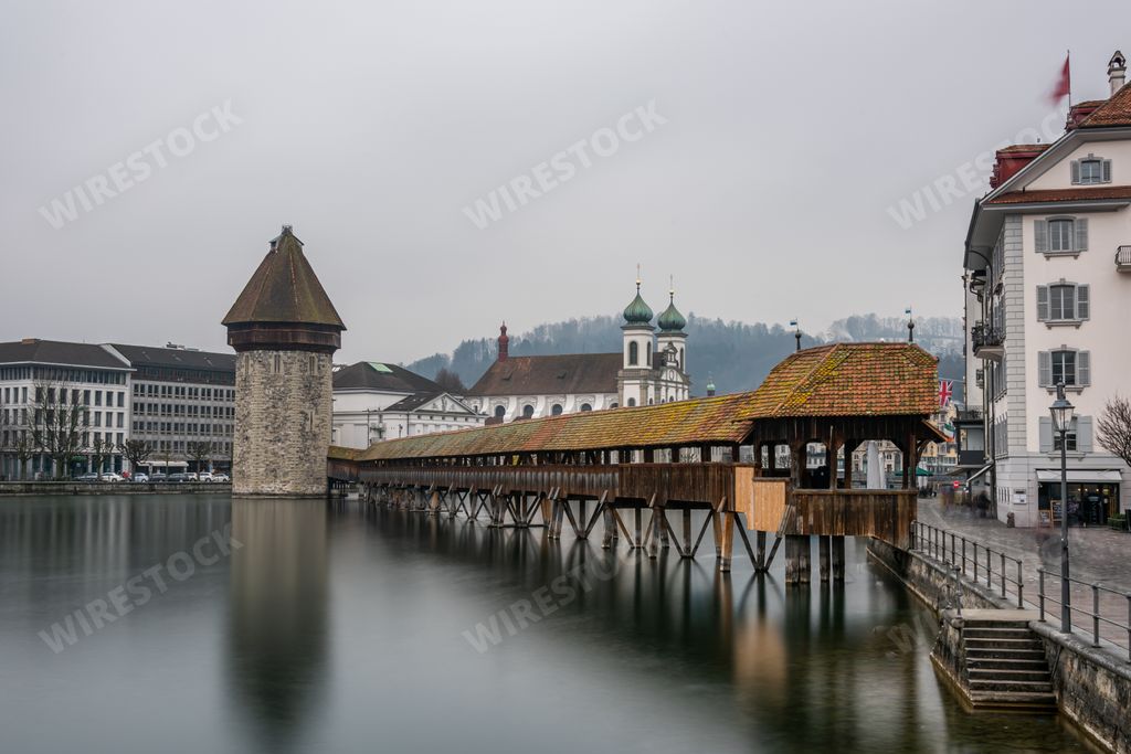 The Lucerne Jesuit Church surrounded by water under a cloudy sky in Lucerne in Switzerland