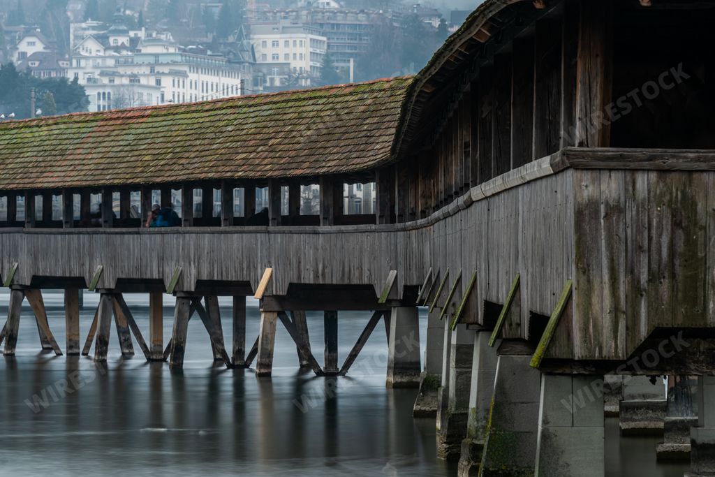 A covered bridge near The Lucerne Jesuit Church surrounded by buildings in Lucerne in Switzerland
